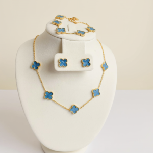 Blue five-clover necklace with matching earrings and bracelet on a white display.