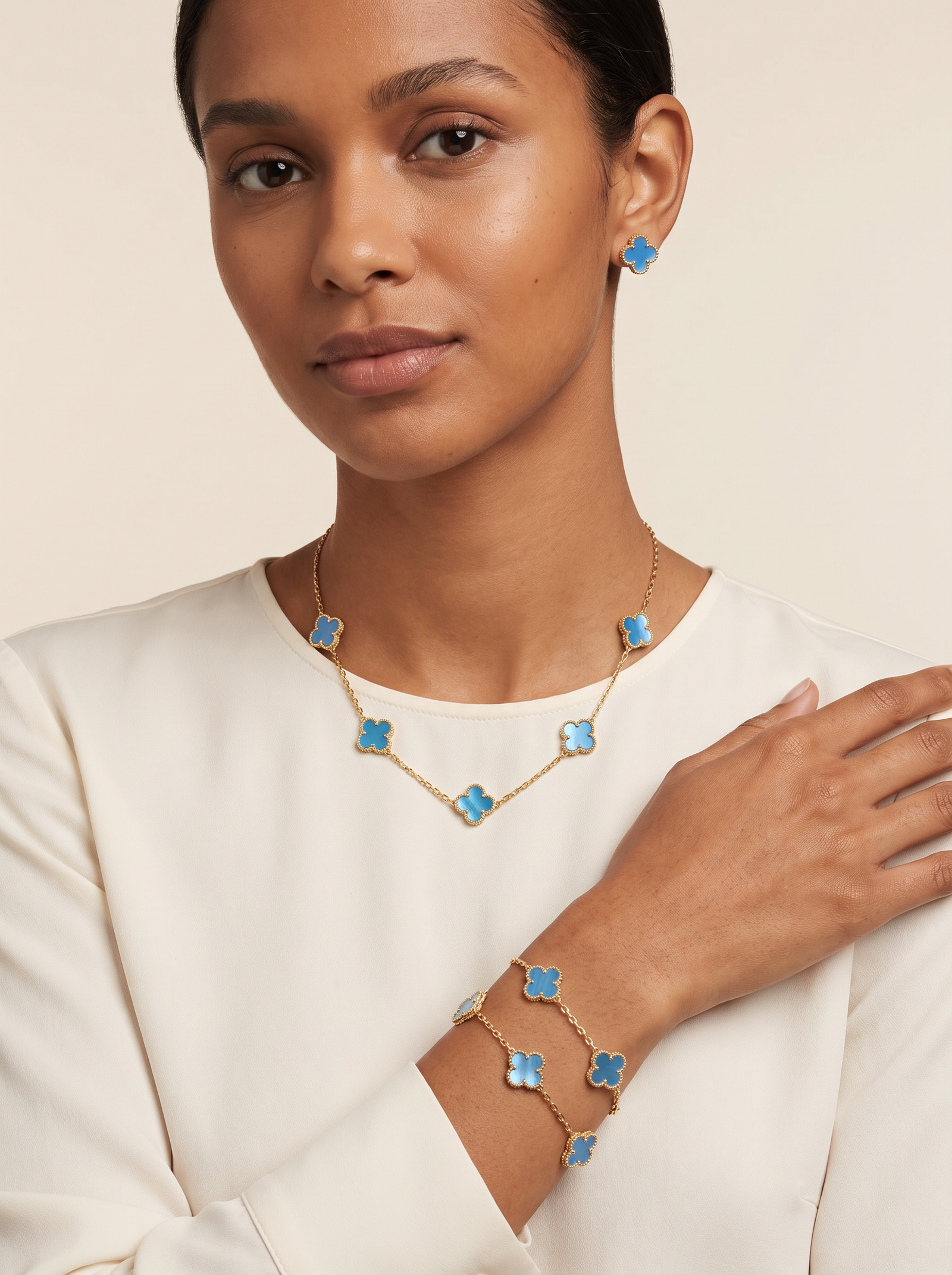 Model wearing the blue multi-clover necklace, coordinating clover earrings and bracelet.