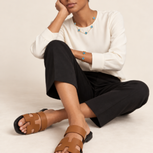 Model wearing tan cutout double-band sandals
