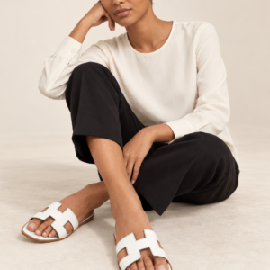 Model wearing white cutout slide sandals