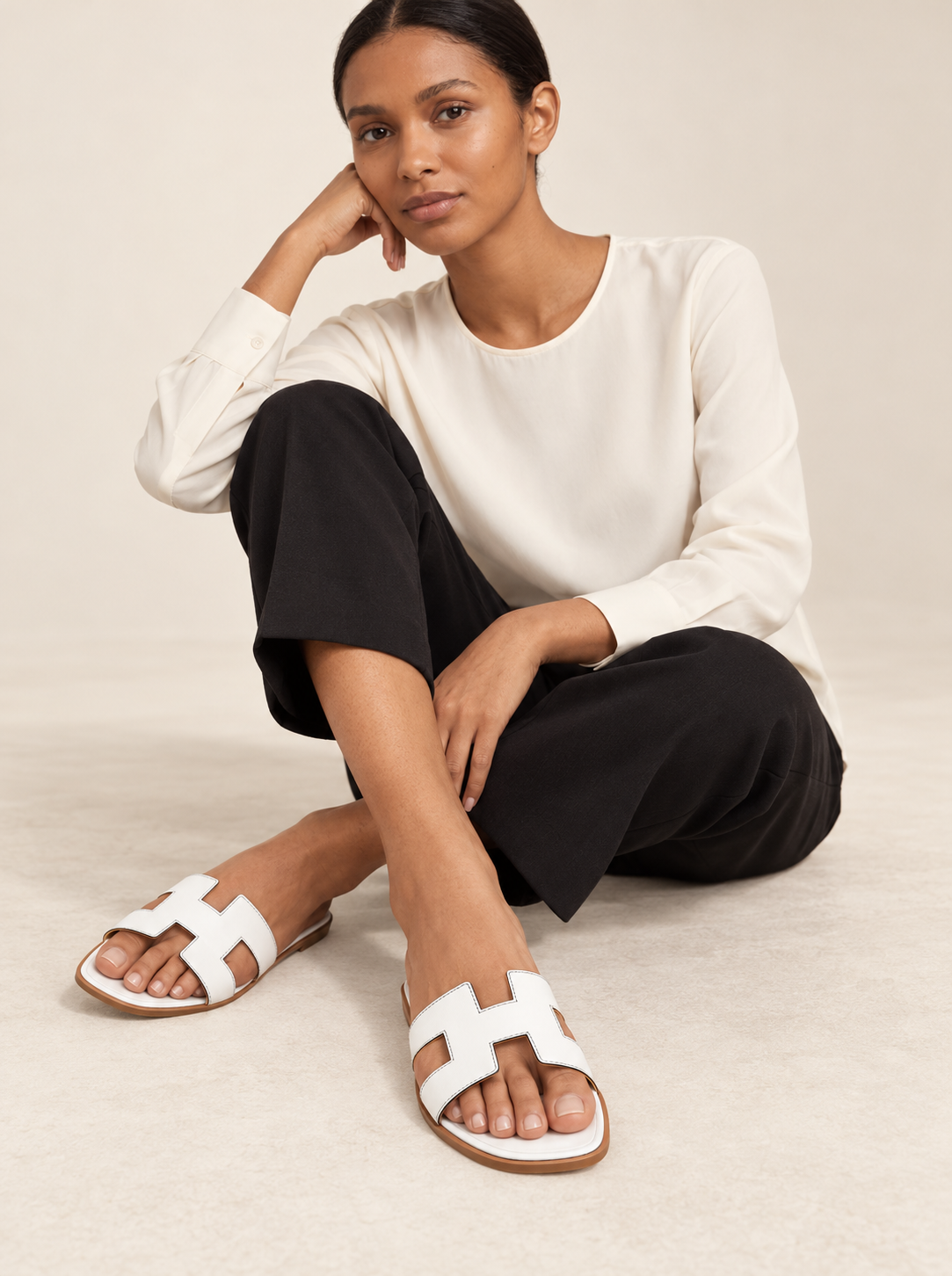 Model wearing white cutout slide sandals